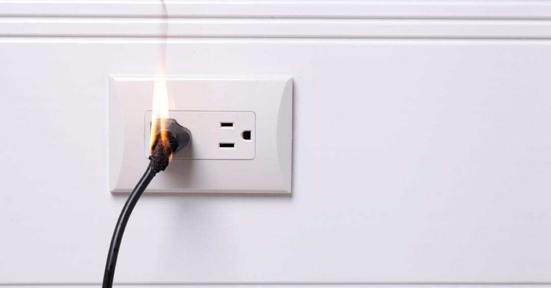 image of an overheated electrical outlet on fire